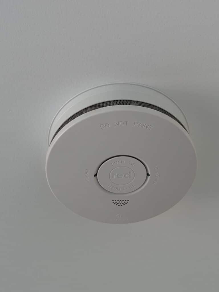 A smoke alarm on a white ceiling.