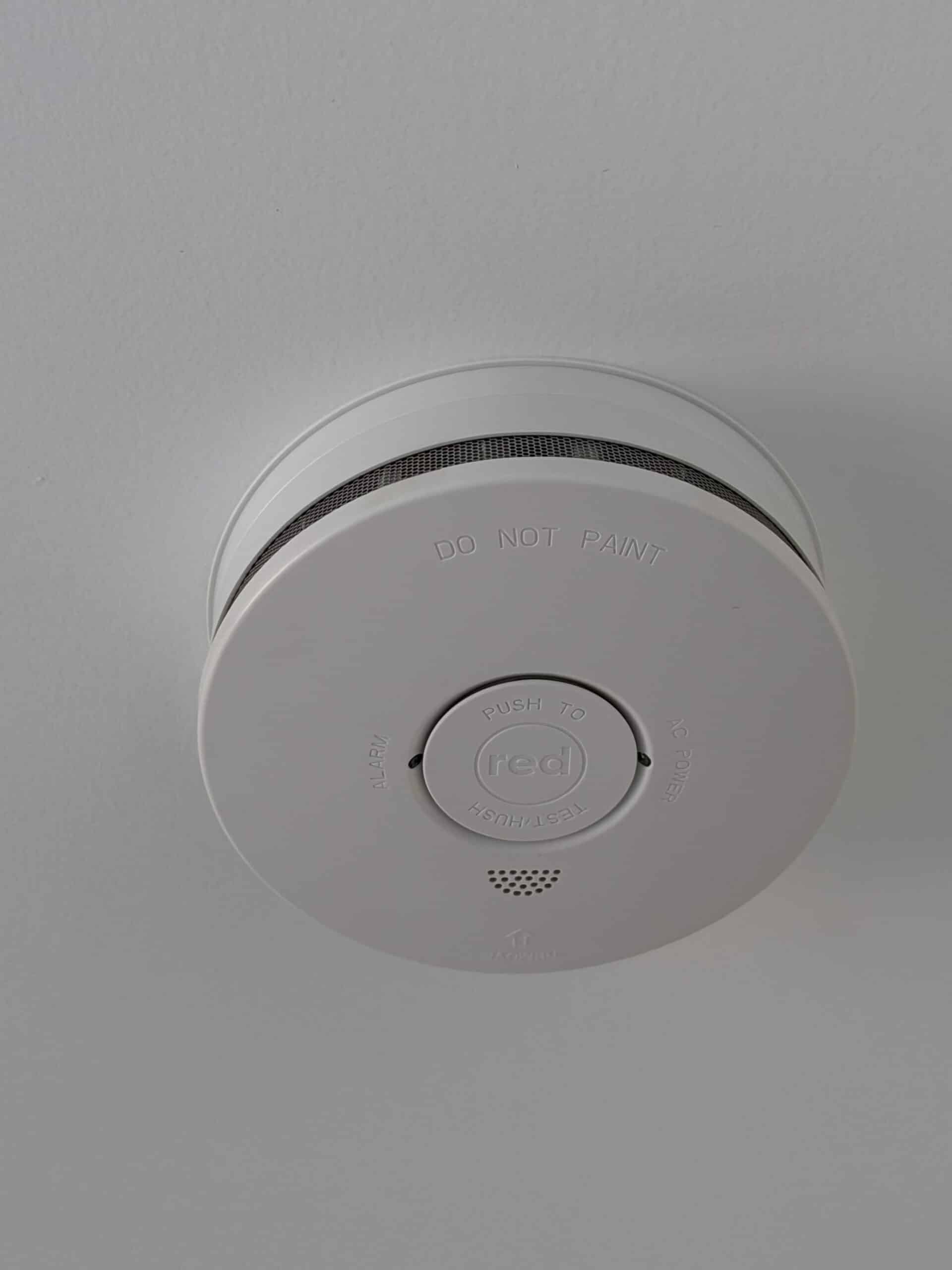 A smoke alarm on a white ceiling.
