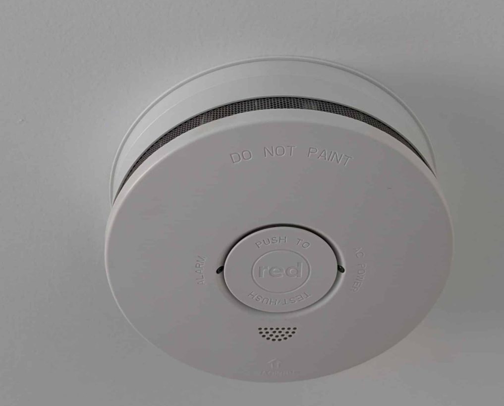 smoke alarm (1) A smoke alarm on a white ceiling.
